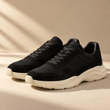 a pair of premium black suede and mesh low-top sneakers with cream sculpted rubber soles, side three-quarter angle