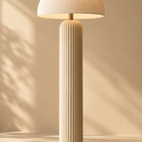 one tall sculptural cream floor lamp with a ribbed cylindrical base and rounded mushroom shade, full height portrait composition
