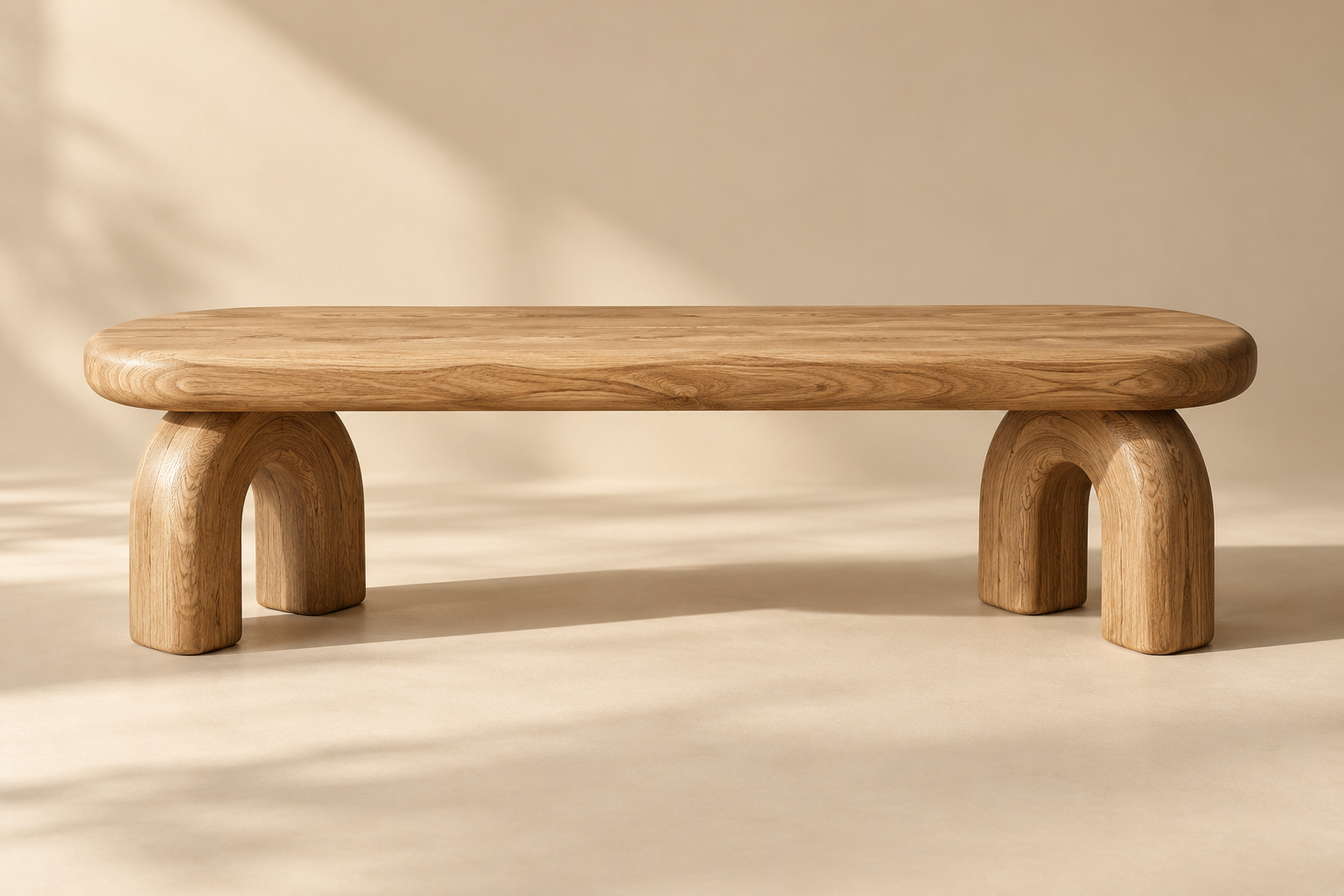 one low sculptural solid oak bench with rounded pill-shaped seat and thick arch legs, full product in wide landscape composition
