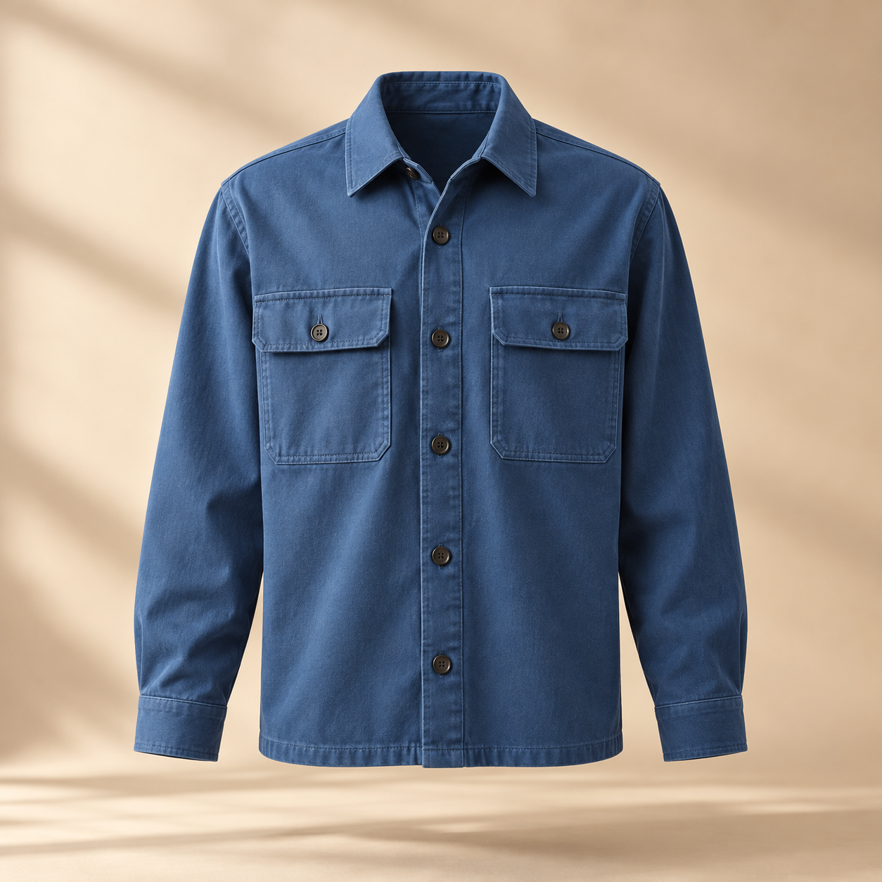 one premium blue cotton twill overshirt with two square chest pockets, tonal buttons and relaxed tailored silhouette, invisible mannequin full front view, no person