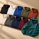 Spectrum Hoodie collection in ten colors, with a teal hoodie in front on a warm studio backdrop